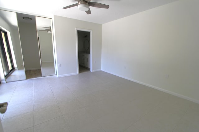 404 Live Oak Ln, Boynton Beach, FL 33436 - unfurnished bedroom with baseboards, ceiling fan, connected bathroom, and light tile patterned flooring