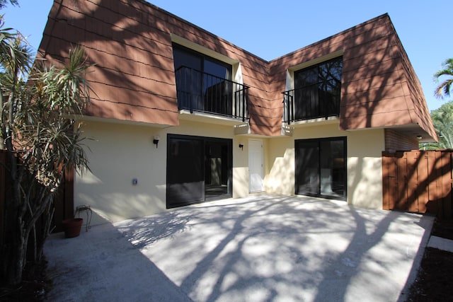 404 Live Oak Ln, Boynton Beach, FL 33436 - rear view of house featuring stucco siding, fence, a patio area, and a balcony