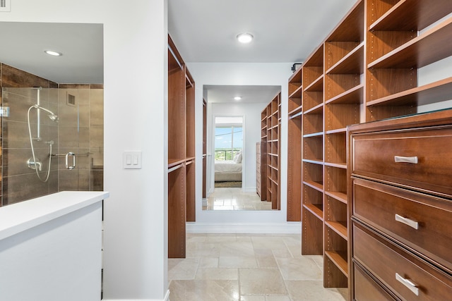 spacious closet featuring stone finish floor