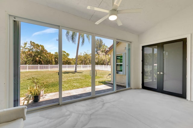 interior space with a ceiling fan, vaulted ceiling, and french doors