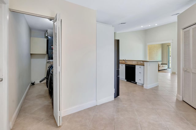 hallway with visible vents, light tile patterned floors, baseboards, a sink, and recessed lighting