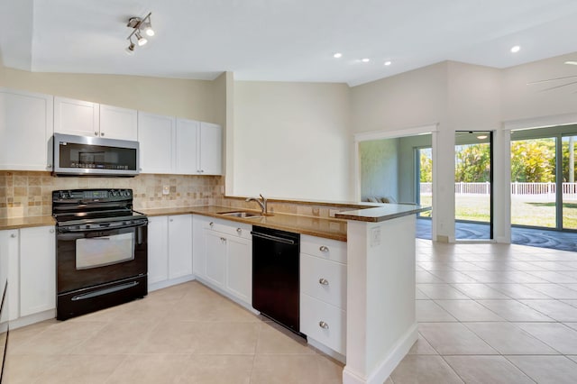 kitchen featuring a sink, decorative backsplash, a peninsula, and black appliances