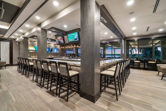 bar with recessed lighting, decorative columns, and wood finished floors