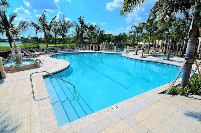 community pool featuring a patio and fence