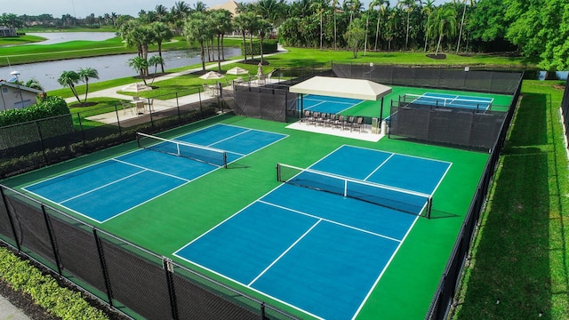 view of sport court featuring fence and a water view