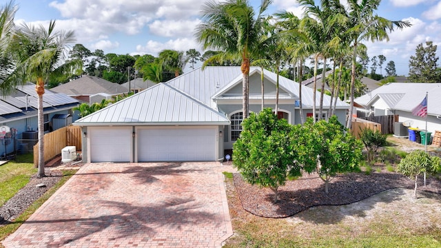 1889 SW Clambake Ave, Port Saint Lucie, FL 34953 - view of front of property with fence, decorative driveway, metal roof, and an attached garage