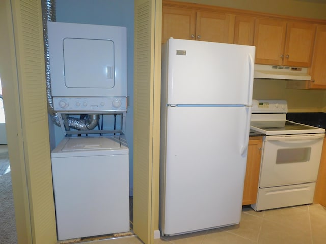 317 Colony Ln Unit A, Fort Pierce, FL 34982 - kitchen featuring white appliances, under cabinet range hood, stacked washer / dryer, light tile patterned flooring, and dark countertops