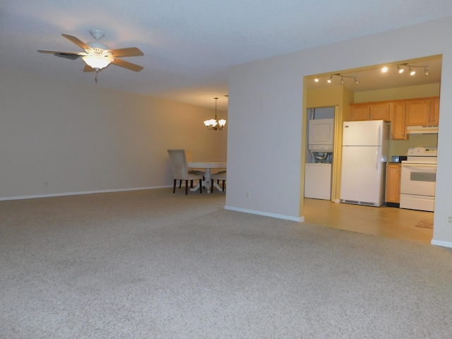 317 Colony Ln Unit A, Fort Pierce, FL 34982 - unfurnished living room featuring stacked washer / dryer, light colored carpet, a chandelier, and baseboards