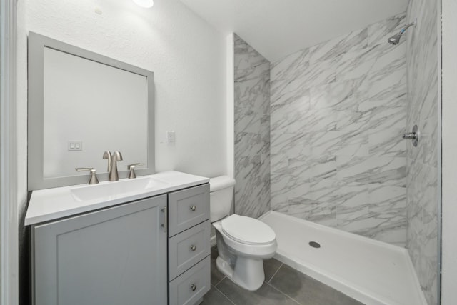 bathroom featuring toilet, a shower stall, and vanity