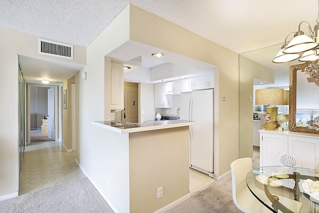 2121 N Ocean Blvd Unit 404W, Boca Raton, FL 33431 - kitchen with light tile patterned floors, white cabinets, freestanding refrigerator, and visible vents