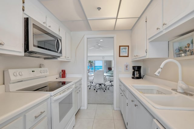 3101 S Ocean Blvd Unit 220, Highland Beach, FL 33487 - kitchen featuring stainless steel microwave, white range with electric stovetop, a sink, light tile patterned flooring, and white cabinets