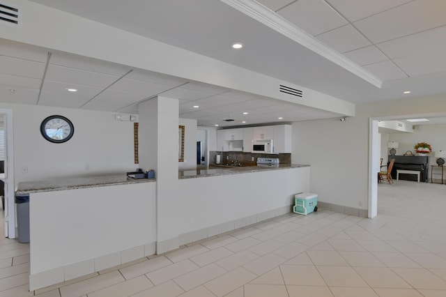 3101 S Ocean Blvd Unit 220, Highland Beach, FL 33487 - kitchen featuring white microwave, white cabinets, tasteful backsplash, stone counters, and a paneled ceiling