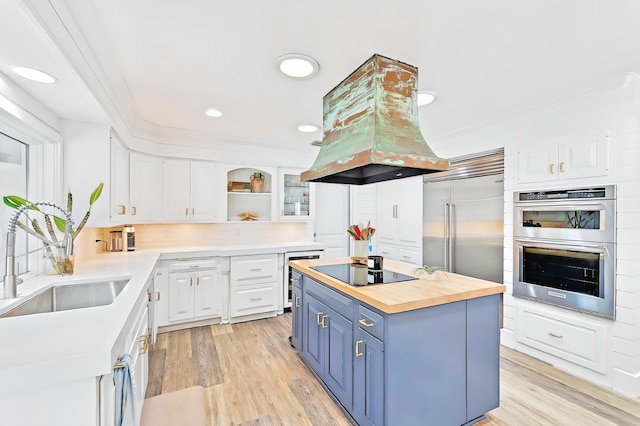 940 Turner Quay, Jupiter, FL 33458 - kitchen featuring wooden counters, white cabinetry, island exhaust hood, blue cabinets, and appliances with stainless steel finishes