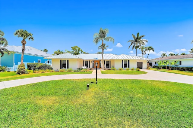940 Turner Quay, Jupiter, FL 33458 - single story home with an attached garage, curved driveway, metal roof, and a front yard