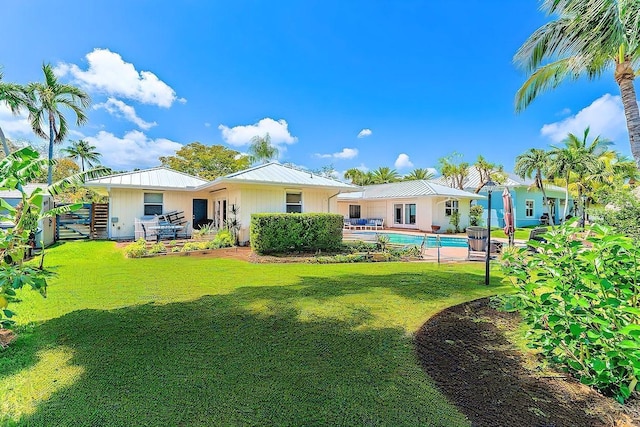 940 Turner Quay, Jupiter, FL 33458 - rear view of property featuring a lawn, metal roof, and an outdoor pool