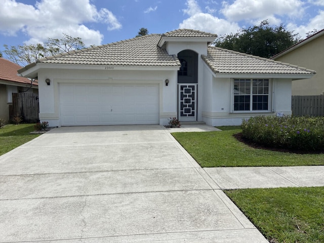 view of front of property featuring a tile roof, a front yard, a garage, concrete driveway, and stucco siding