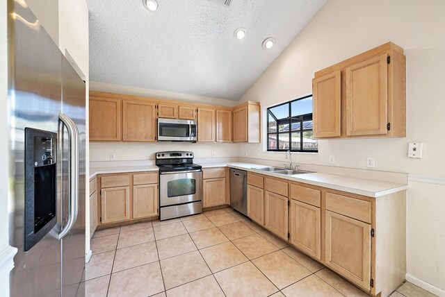 6089 Adams St, Jupiter, FL 33458 - kitchen with a sink, lofted ceiling, light brown cabinetry, light countertops, and appliances with stainless steel finishes