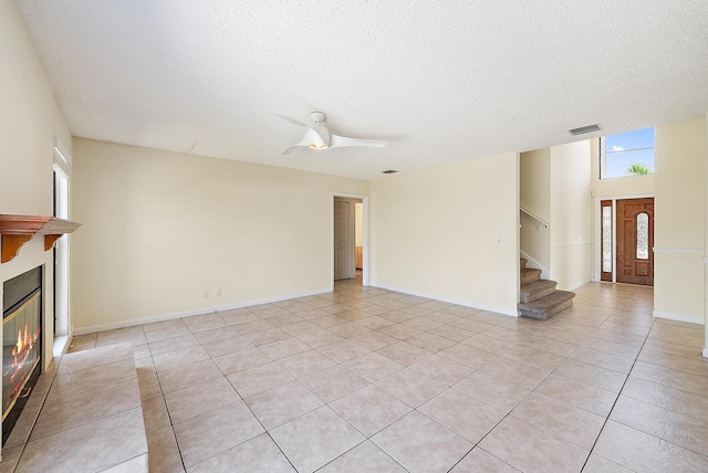 6089 Adams St, Jupiter, FL 33458 - unfurnished living room featuring a textured ceiling, visible vents, light tile patterned floors, and stairs