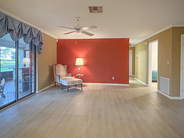living area with visible vents, crown molding, and light wood-style flooring