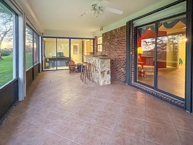 sunroom / solarium with a ceiling fan and outdoor dry bar