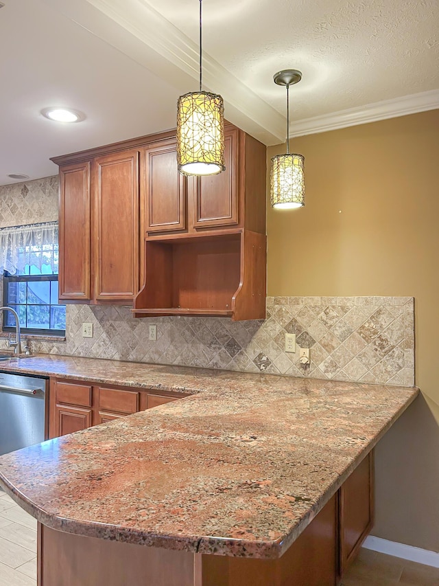 kitchen featuring a sink, brown cabinetry, light stone counters, backsplash, and pendant lighting