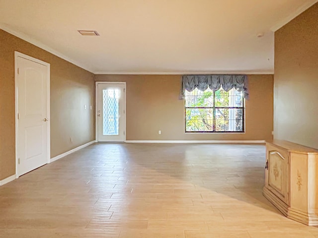 unfurnished room featuring baseboards, light wood-type flooring, and ornamental molding
