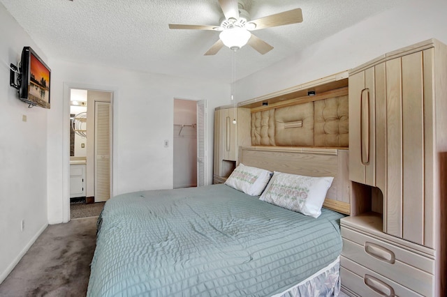 bedroom with carpet flooring, a closet, a ceiling fan, a textured ceiling, and a spacious closet