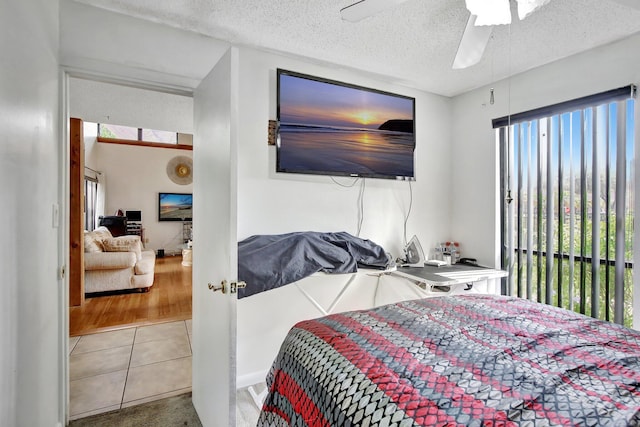 bedroom with tile patterned flooring, a ceiling fan, and a textured ceiling