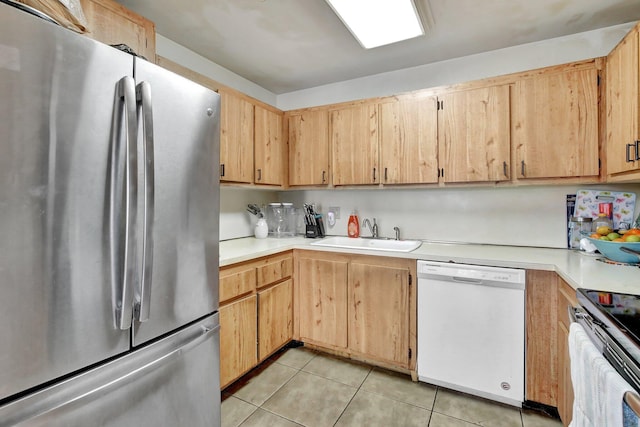kitchen with a sink, range with electric cooktop, light tile patterned floors, dishwasher, and freestanding refrigerator