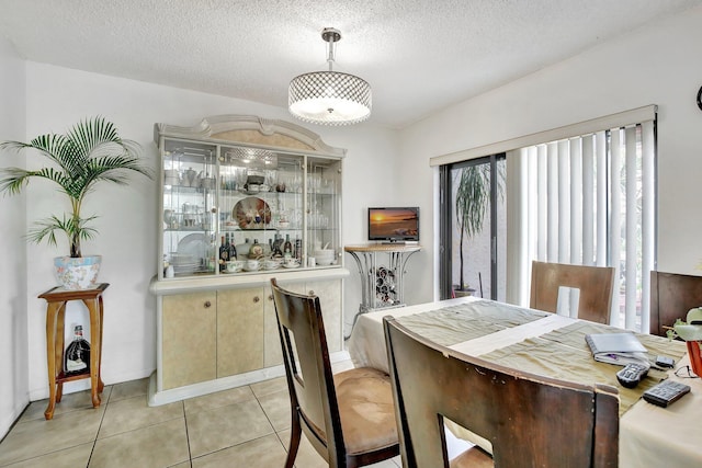 dining space featuring a textured ceiling and light tile patterned flooring