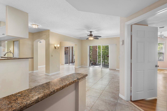 3211 Tuscany Way, Boynton Beach, FL 33435 - unfurnished living room with a ceiling fan, arched walkways, baseboards, ornamental molding, and light tile patterned flooring