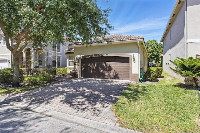 1023 Center Stone Ln, Riviera Beach, FL 33404 - view of front facade with an attached garage, a front lawn, a tile roof, stucco siding, and driveway