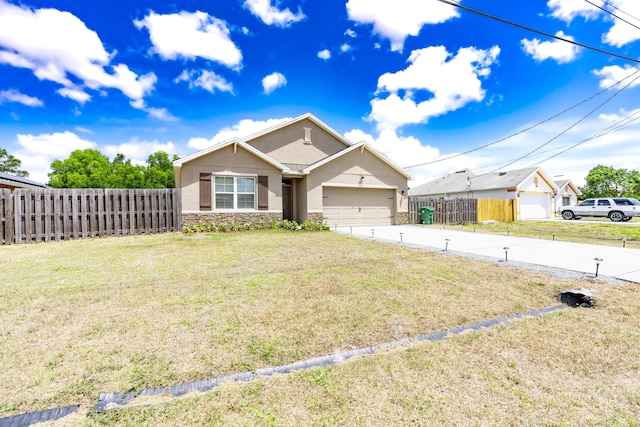 551 SW Lairo Ave, Port Saint Lucie, FL 34953 - view of front of home with stucco siding, fence, stone siding, concrete driveway, and an attached garage