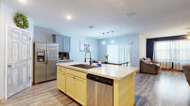 551 SW Lairo Ave, Port Saint Lucie, FL 34953 - kitchen featuring a sink, light wood-style floors, stainless steel appliances, light countertops, and open floor plan
