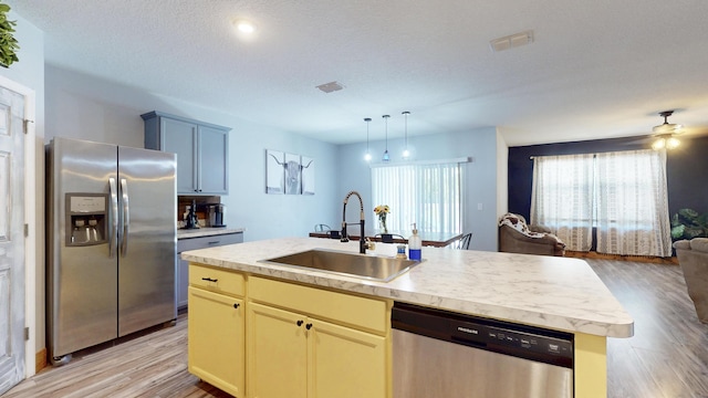 551 SW Lairo Ave, Port Saint Lucie, FL 34953 - kitchen with a sink, stainless steel appliances, light wood-style floors, light countertops, and open floor plan