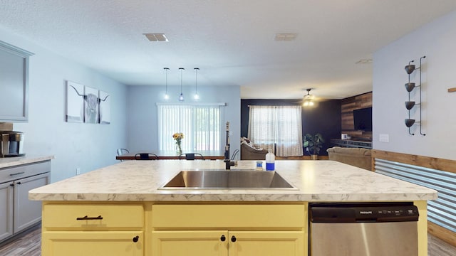 551 SW Lairo Ave, Port Saint Lucie, FL 34953 - kitchen featuring open floor plan, wood finished floors, stainless steel dishwasher, and light countertops