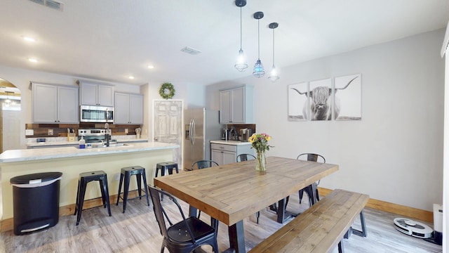 551 SW Lairo Ave, Port Saint Lucie, FL 34953 - dining space with baseboards, visible vents, arched walkways, and light wood-style flooring