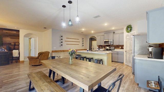 551 SW Lairo Ave, Port Saint Lucie, FL 34953 - dining room featuring visible vents, light wood-style floors, recessed lighting, and arched walkways