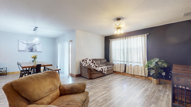 551 SW Lairo Ave, Port Saint Lucie, FL 34953 - living room with baseboards, visible vents, wood finished floors, and a textured ceiling