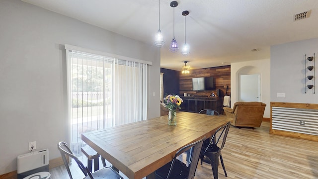 551 SW Lairo Ave, Port Saint Lucie, FL 34953 - dining space featuring wood walls, visible vents, a ceiling fan, and light wood-style flooring