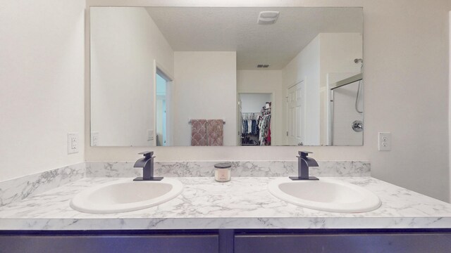 551 SW Lairo Ave, Port Saint Lucie, FL 34953 - bathroom with double vanity, a walk in closet, a shower stall, and a sink
