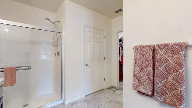 551 SW Lairo Ave, Port Saint Lucie, FL 34953 - full bathroom featuring visible vents, a spacious closet, tile patterned flooring, and a stall shower