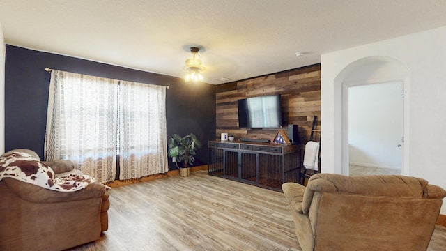 551 SW Lairo Ave, Port Saint Lucie, FL 34953 - living area with ceiling fan, wooden walls, baseboards, arched walkways, and wood finished floors