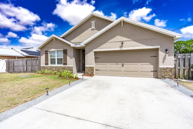 551 SW Lairo Ave, Port Saint Lucie, FL 34953 - ranch-style home with a front lawn, a garage, stone siding, stucco siding, and fence