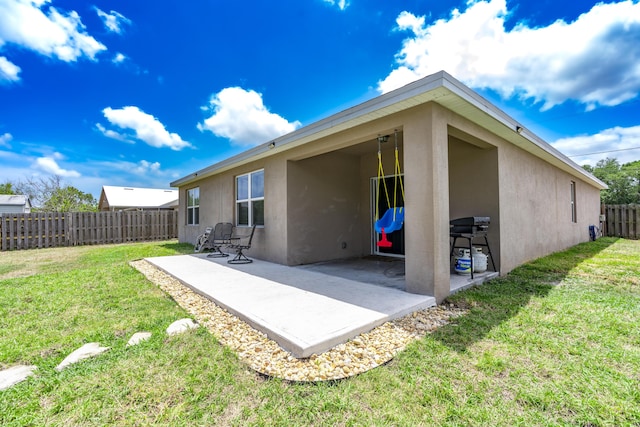 551 SW Lairo Ave, Port Saint Lucie, FL 34953 - back of house featuring a patio, fence, stucco siding, and a lawn
