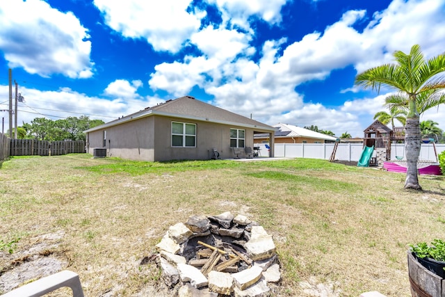 551 SW Lairo Ave, Port Saint Lucie, FL 34953 - view of yard with cooling unit, a fenced backyard, a patio area, and a playground