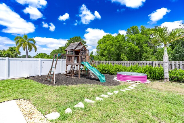 551 SW Lairo Ave, Port Saint Lucie, FL 34953 - view of jungle gym featuring a yard and a fenced backyard
