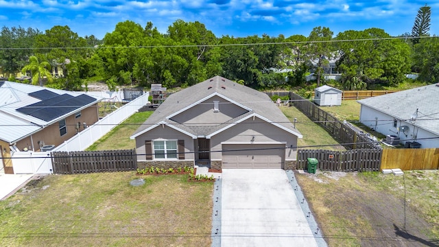 551 SW Lairo Ave, Port Saint Lucie, FL 34953 - view of front of home with a front lawn, a fenced backyard, stone siding, concrete driveway, and an attached garage