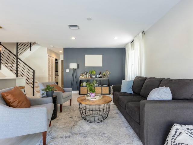 living room featuring wood finished floors, visible vents, recessed lighting, and stairs