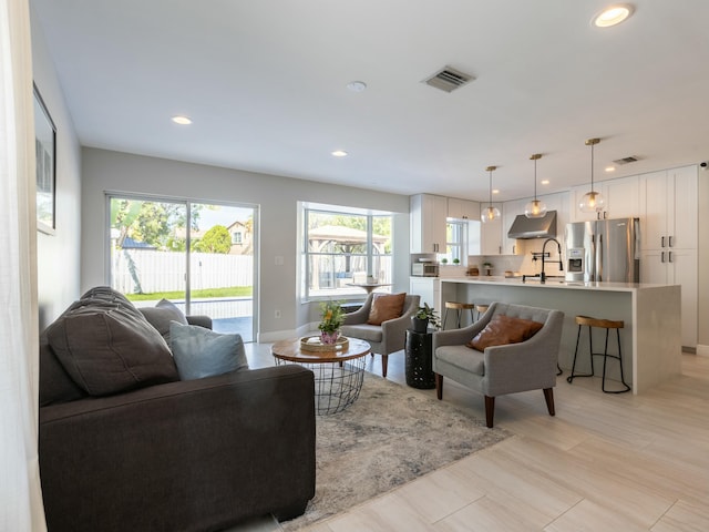 living area with baseboards, visible vents, and recessed lighting